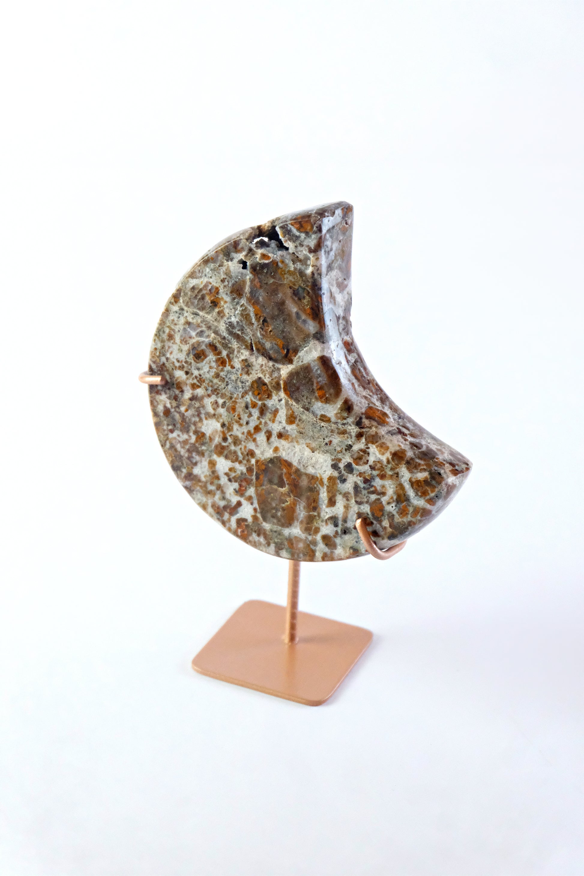 Decorative half-moon stone on a stand against a white background